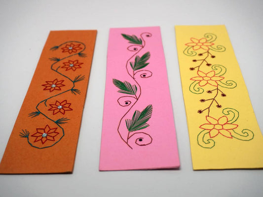 Three embroidered bookmarks with flowers